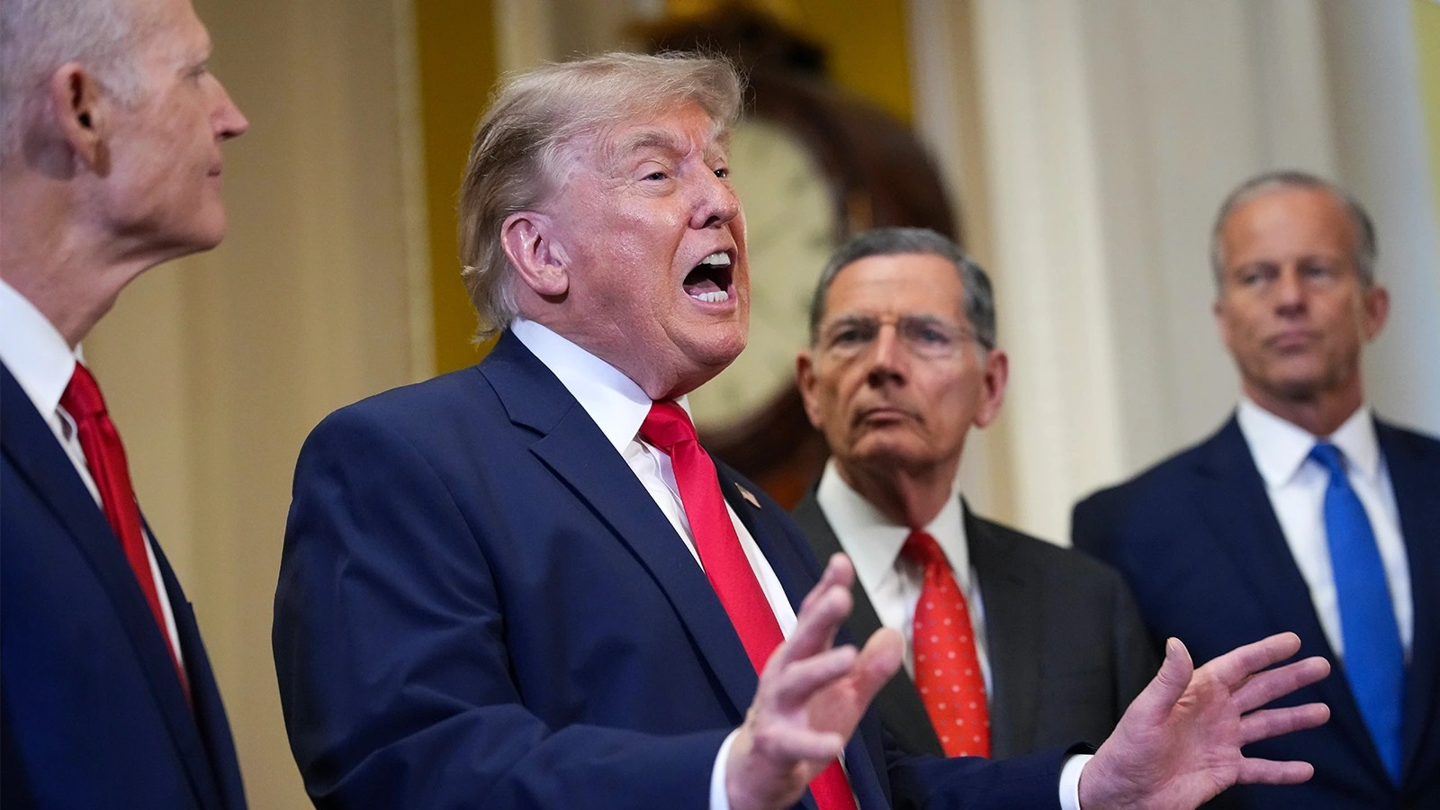 From left: Rick Scott, John Barrasso, Donald Trump, John Thune. Trump speaks with his mouth open while gesturing with both hands.