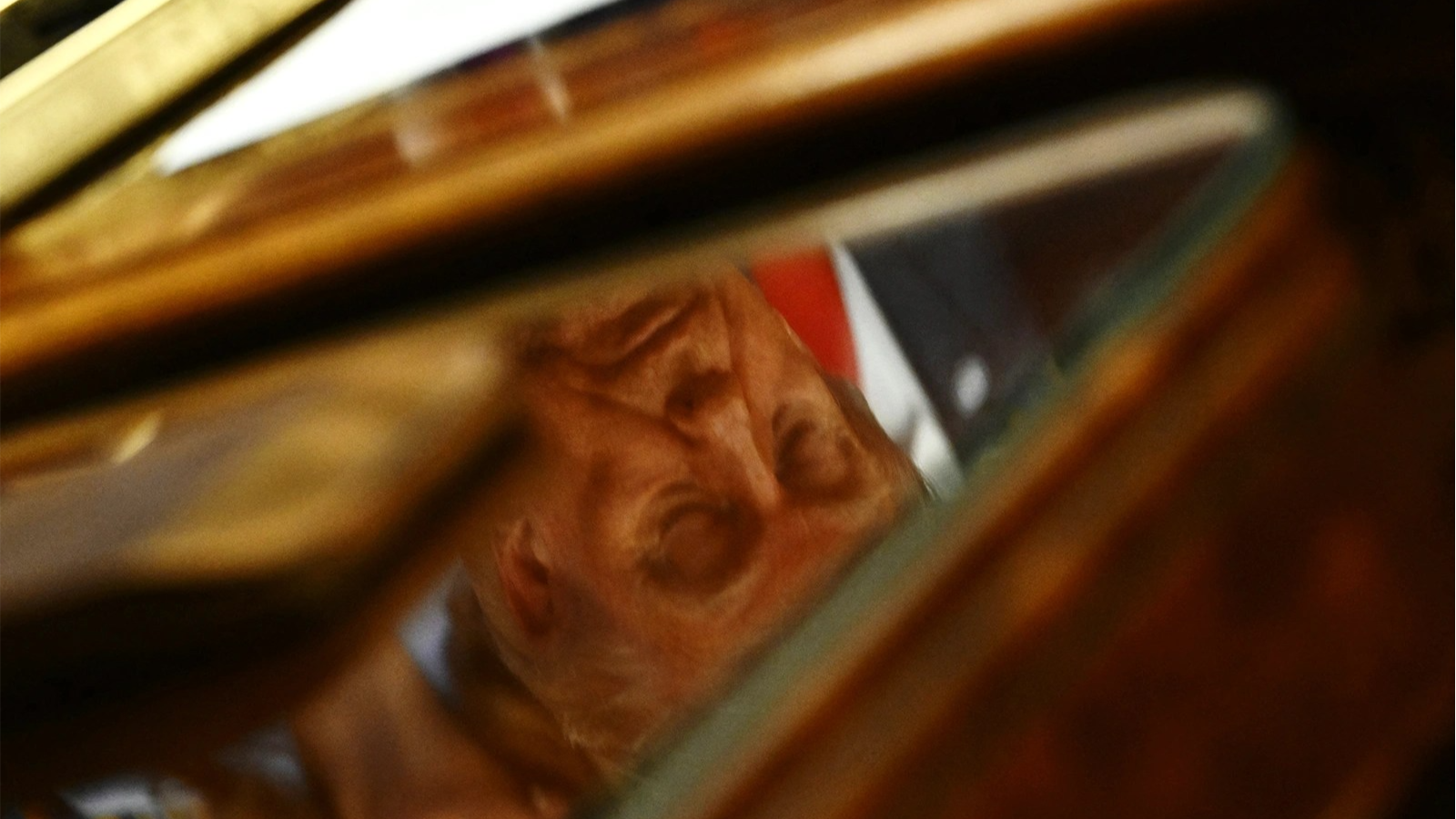 President Donald Trump's reflection is seen on a table during a Maternal Healthcare Event in the Oval Office on May 11, 2026.