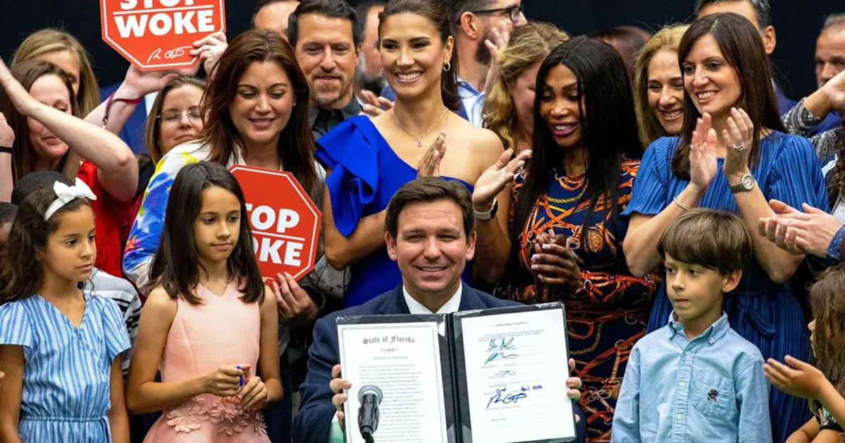 Governor Ron DeSantis holding a signed bill