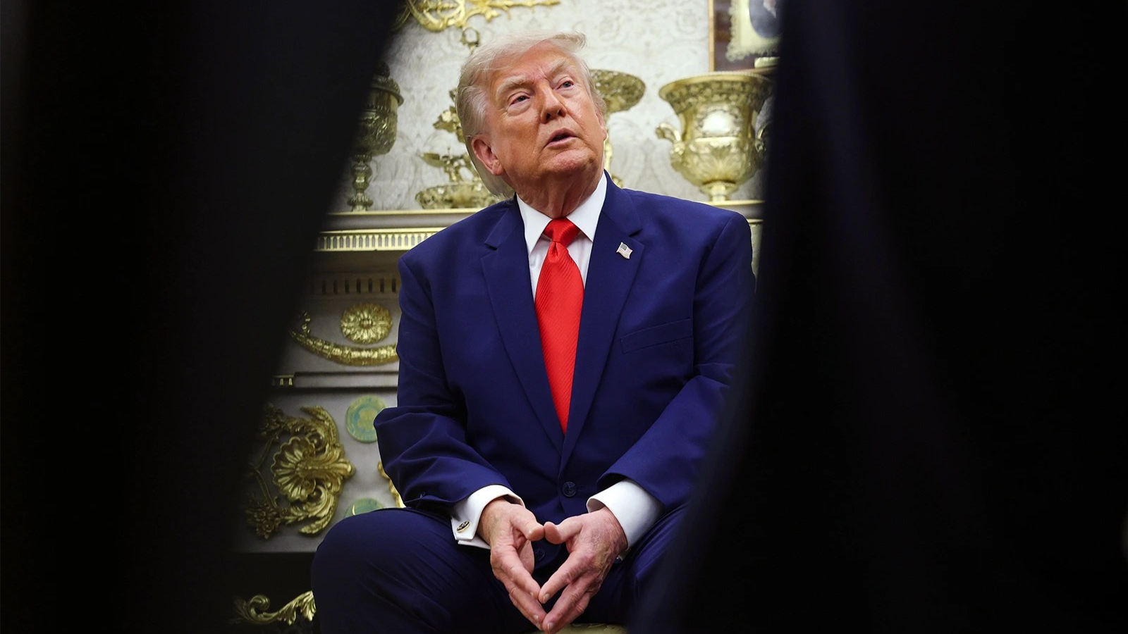 Donald Trump sits in the Oval Office