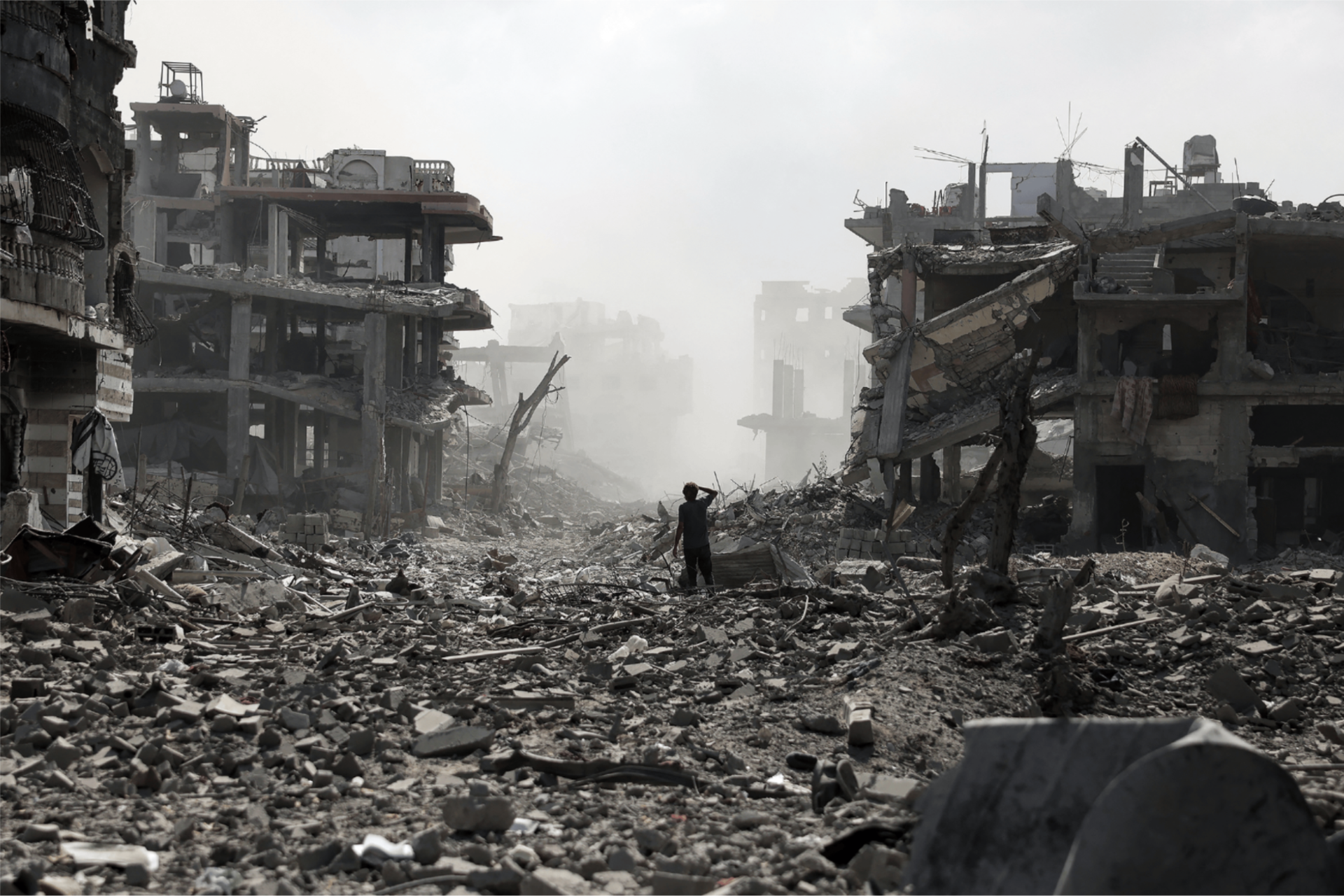 A Palestinian youth stands on a street strewn with rubble in the northern Gaza Strip.