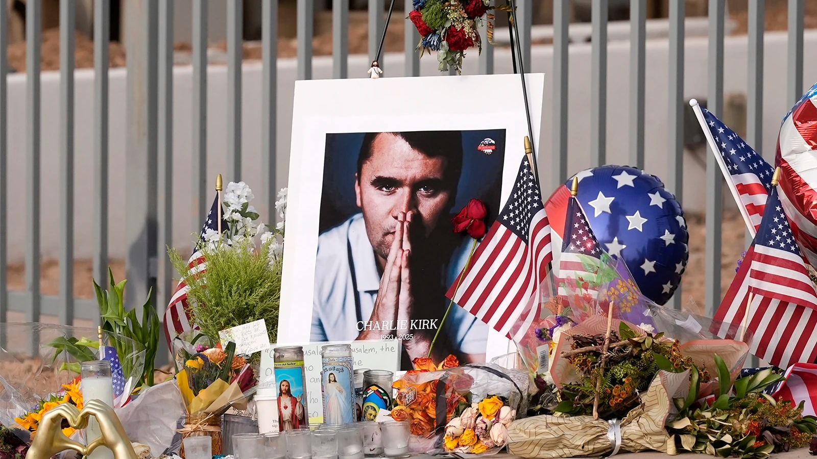 Photo of Charlie Kirk among U.S. flags and flowers