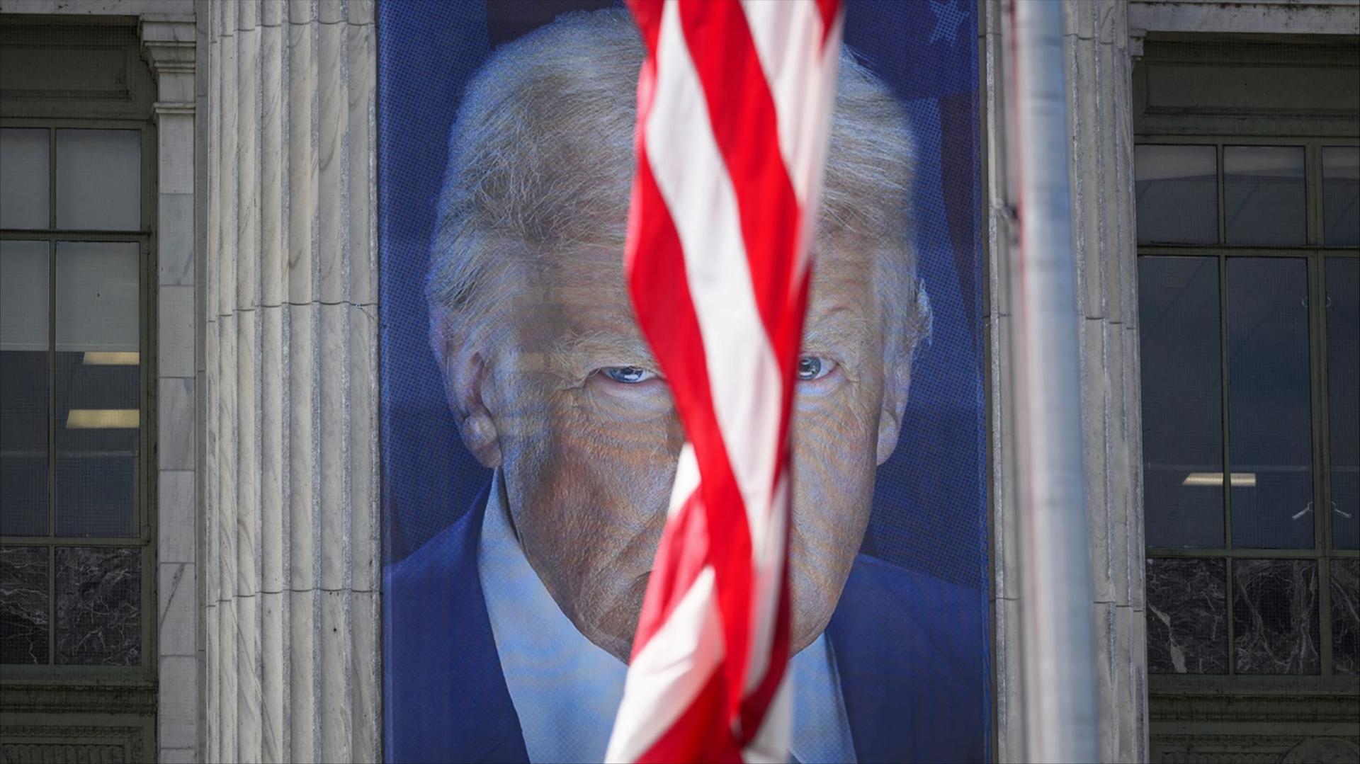 A banner showing an image of Trump behind a US flag