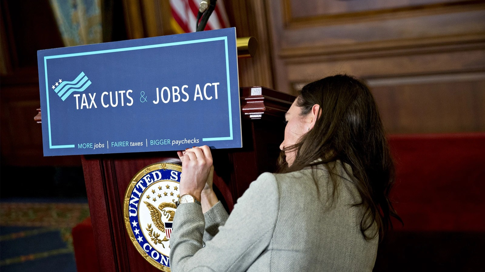 A staff member places a sign on a podium before a news conference at the Capitol in 2017