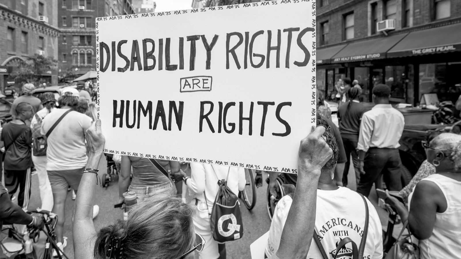 A person holds a sign that reads 