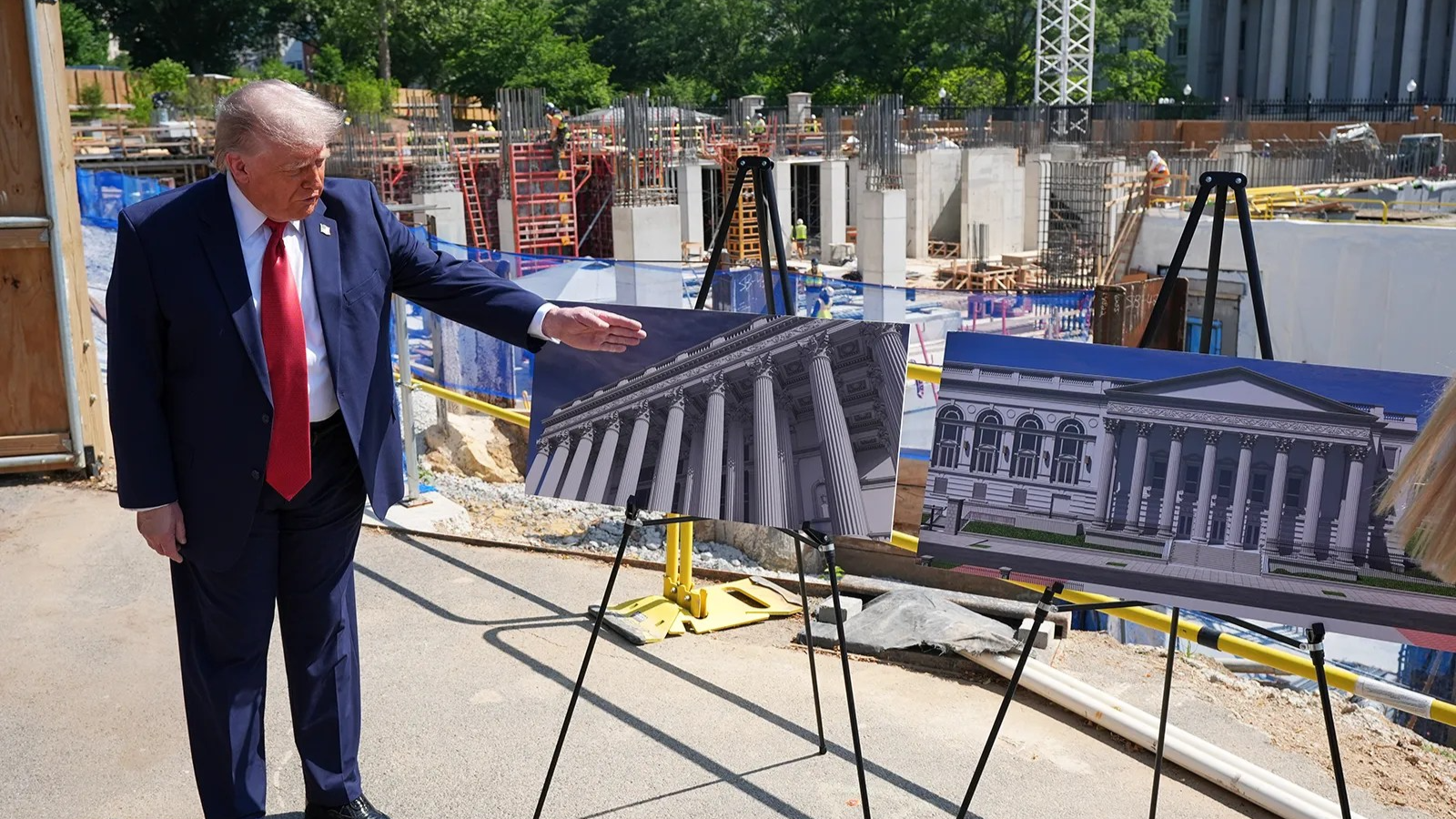 Donald Trump points at renderings of ballroom in front of its construction site.