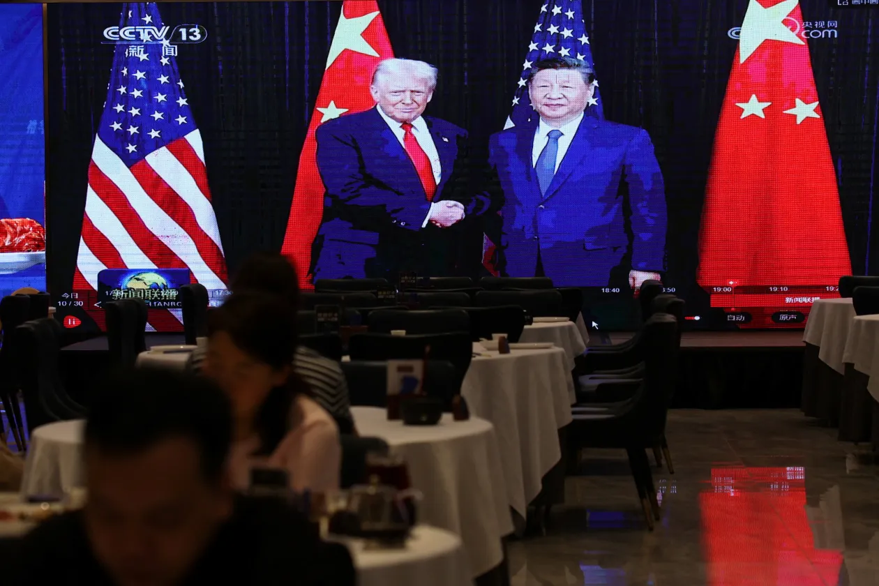 A screen shows news footage of the bilateral meeting between Chinese President Xi Jinping and U.S. President Donald Trump on the sidelines of the Asia-Pacific Economic Cooperation (APEC) summit in South Korea's Busan, at a restaurant in Shenzhen, Guangdong province, China October 30, 2025. 