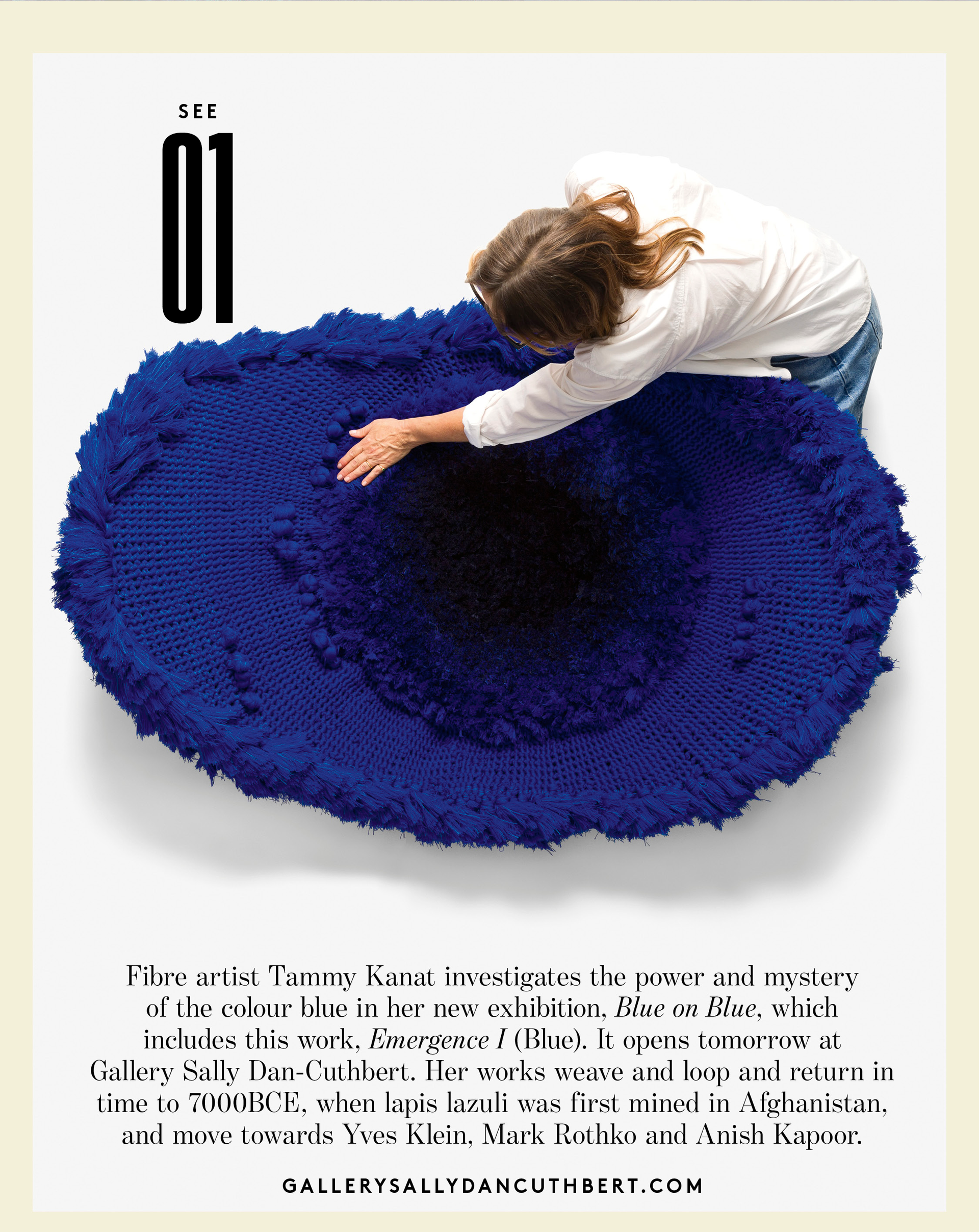 Woman leaning over blue textile art by Tammy Kanat