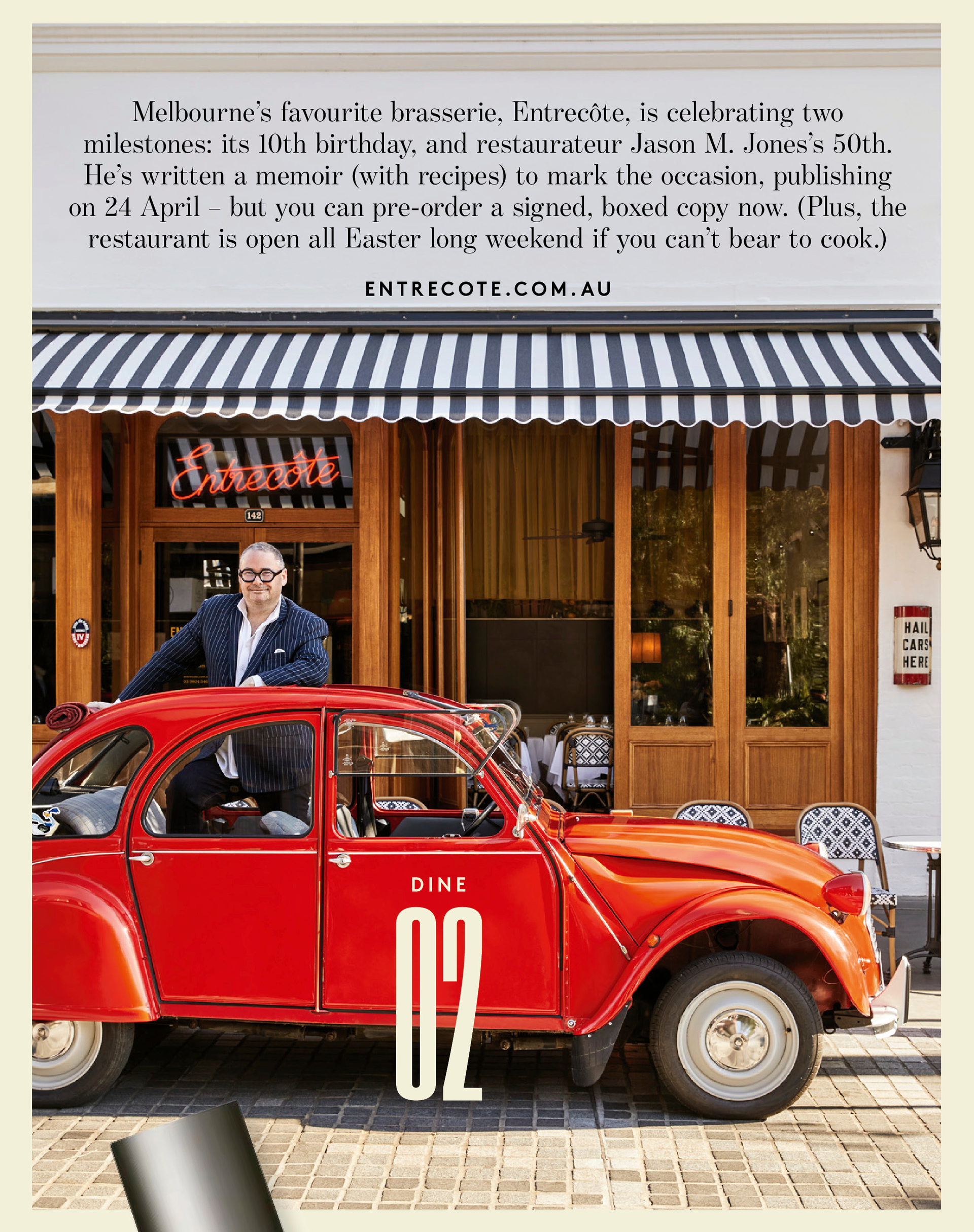 Man in pinstripe suit leans on red Deux Chevaux car outside timber-fronted restaurant with striped awning
