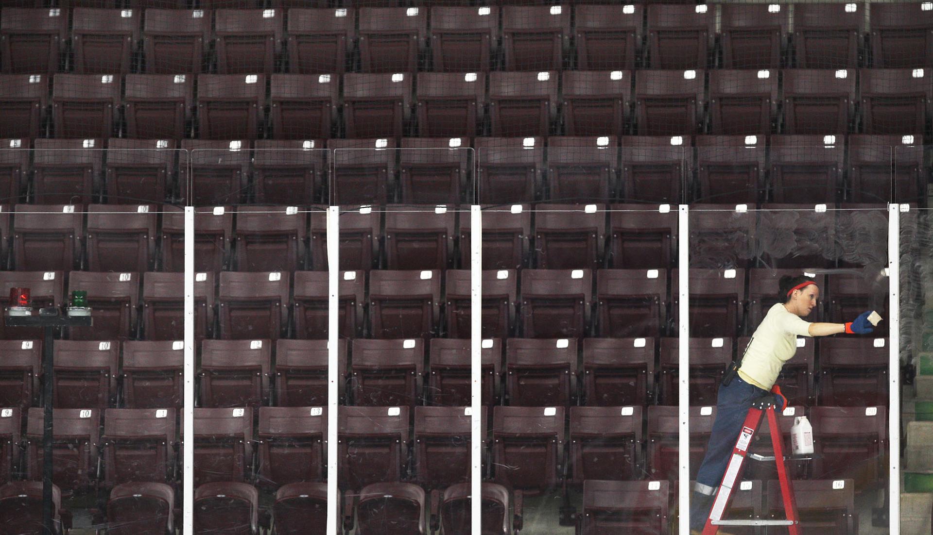 A city worker cleans the glass along the boards at WFCU Centre in Windsor, Ont.
