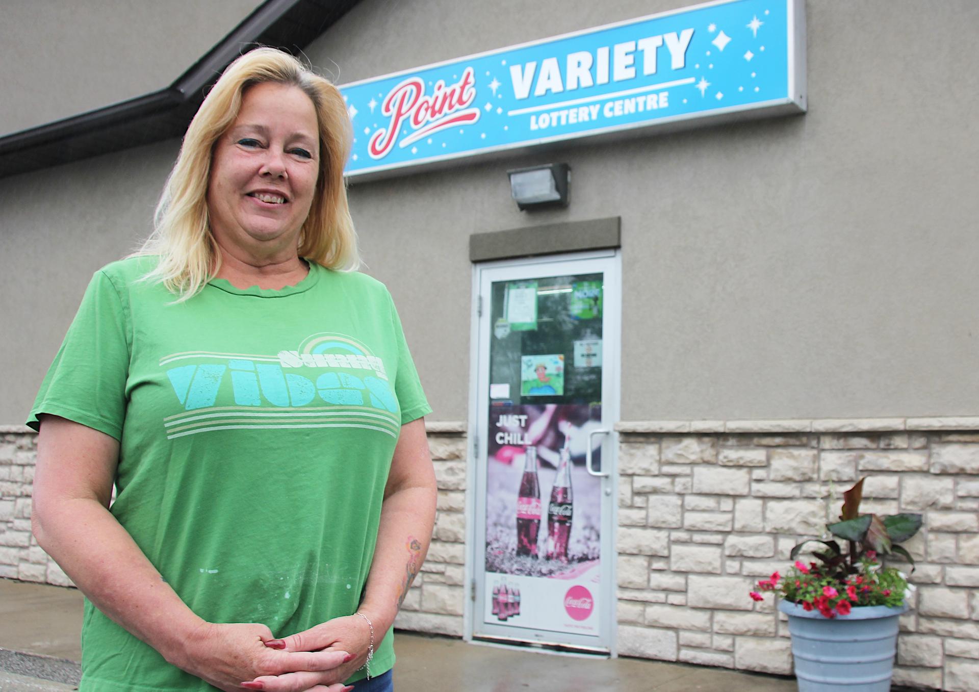 A woman standing outside variety store