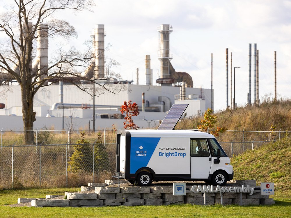 The Cami assembly plant smokestacks behind a BrightDrop electric van in Ingersoll, Ontario.