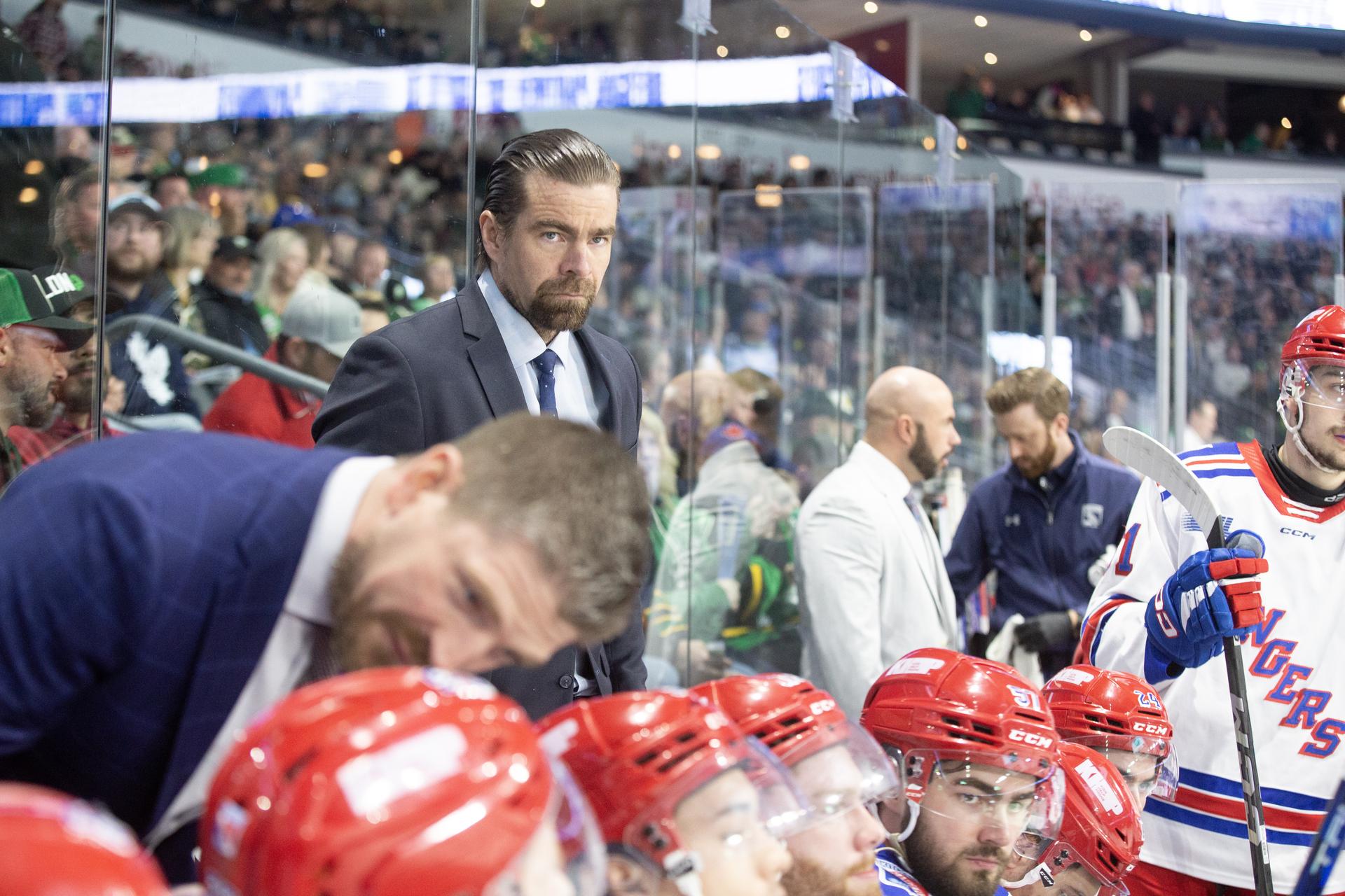 Kitchener Rangers head coach Jussi Ahokas peers out from the team's bench during an OHL game.
