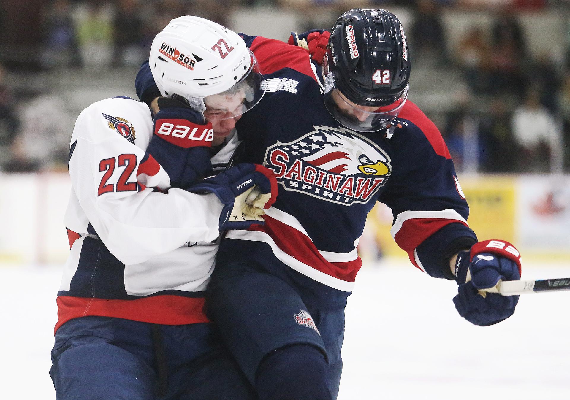 Windsor's J.C. Lemieux and Saginaw's Jacob Cloutier wrestle for position during an OHL pre-season game in Chatham, Ont.