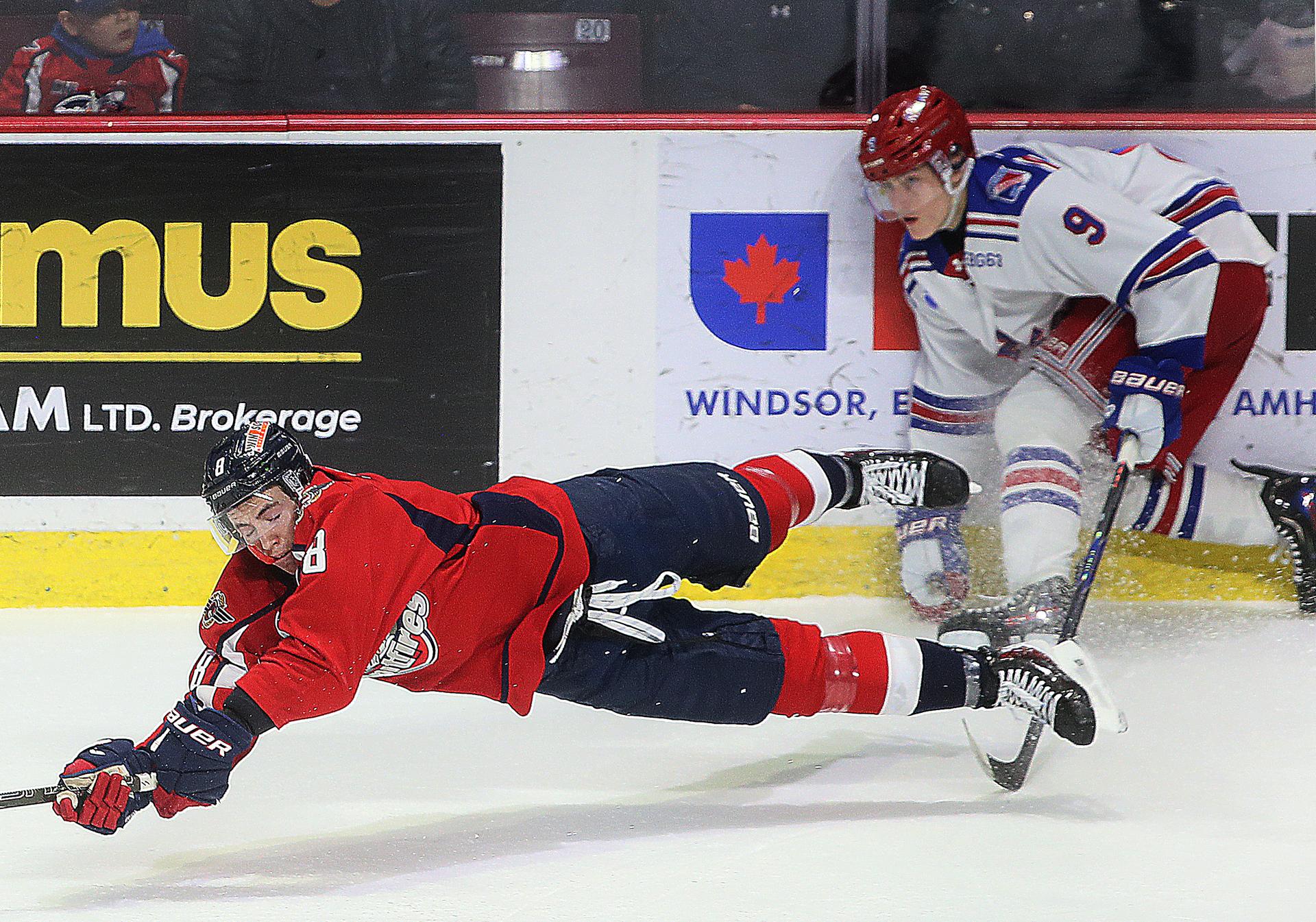 Windsor Spitfire AJ Spellacy gets tripped up by Kitchener Ranger Avry Anstis during an OHL game.