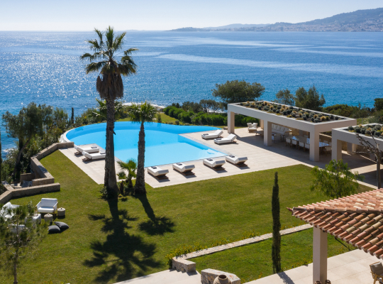 A villa backyard pool and lounge area overlooking the sea.