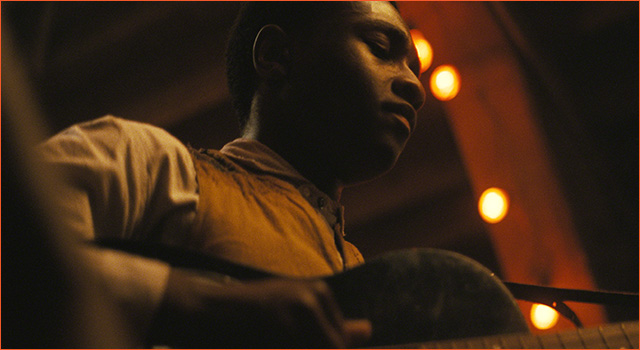 Miles Canton playing the guitar in SINNERS.