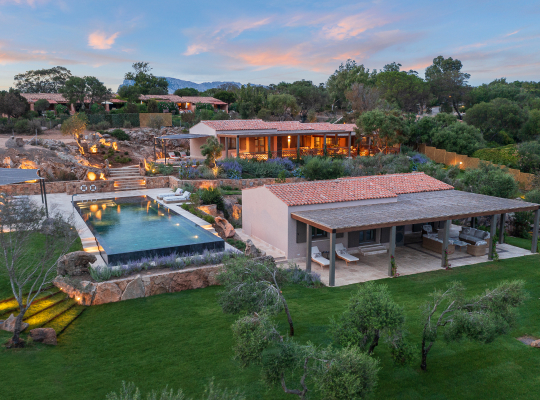 A villa backyard with a pool and lounge area.