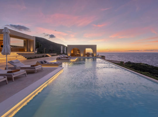A villa backyard with an infinity pool and view of the sea.