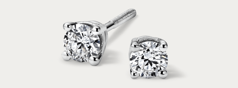 White gold round diamond stud earrings in four-prong setting.