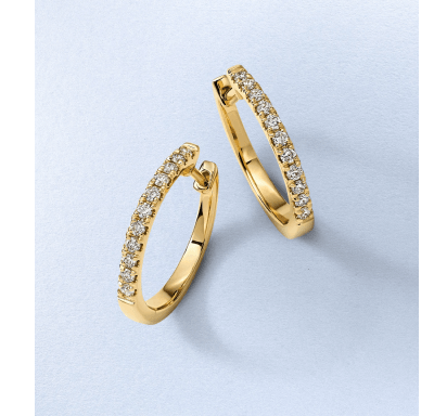 Yellow gold hoop earrings accented with a row of round diamonds.