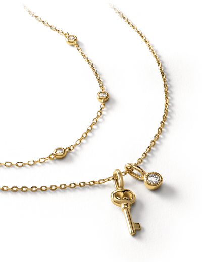 Yellow gold necklaces featuring bezel-set round clear stones, a key charm and a bezel-set oval pendant.