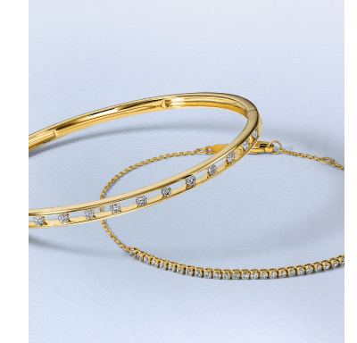 Yellow gold bracelets featuring round diamond details and a diamond tennis chain.