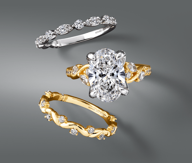 An oval diamond engagement ring with diamond-accented gold and white gold bands.