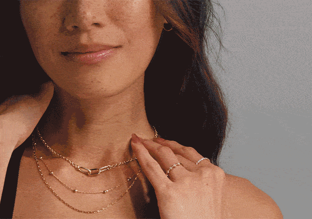 Woman and man showcasing layered yellow gold jewelry in an up-close animated sequence.