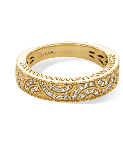 A yellow gold diamond band with milgrain detailing and scrollwork accents