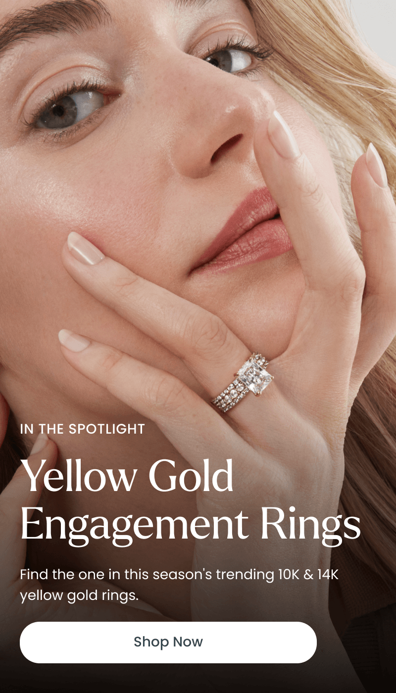 Woman wearing a radiant-cut diamond engagement ring with a pavé diamond band. Yellow gold engagement rings. Click shop now.