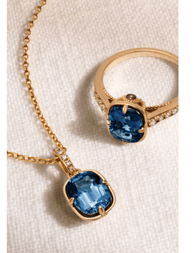 Gold necklace and ring featuring cushion-cut blue topaz gemstones with diamond accents.