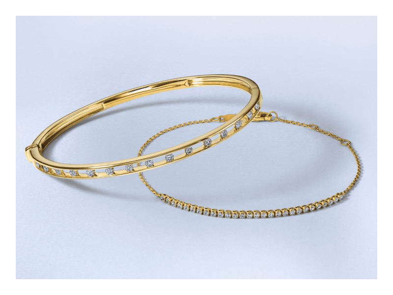 A yellow gold bangle and tennis bracelet accented with round diamonds.