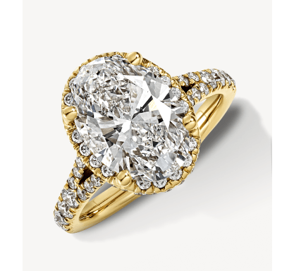 Yellow gold engagement ring with a cushion-cut diamond centre stone, halo and split pavé band.