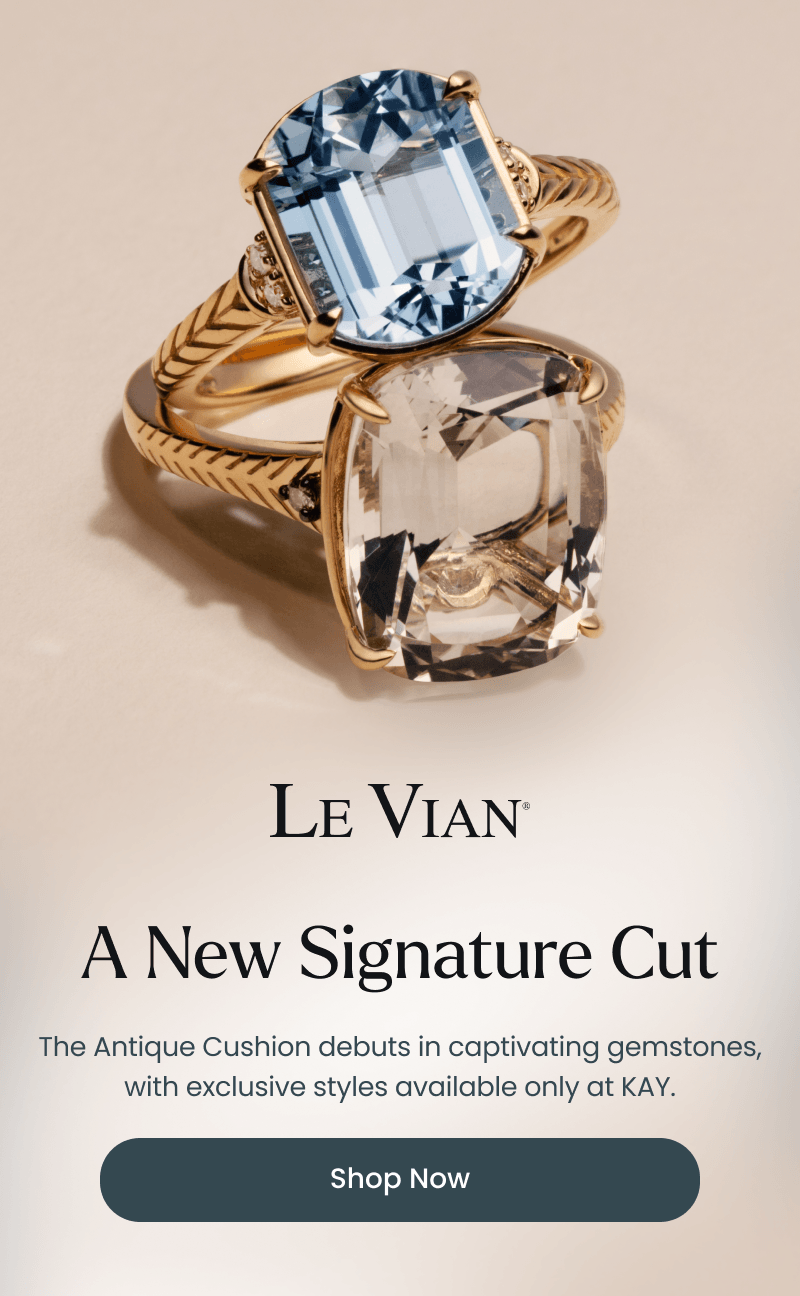 Two Le Vian gold rings featuring oversized cushion-cut gemstones in blue and clear hues, with textured gold bands and diamond accents. Click shop now.
