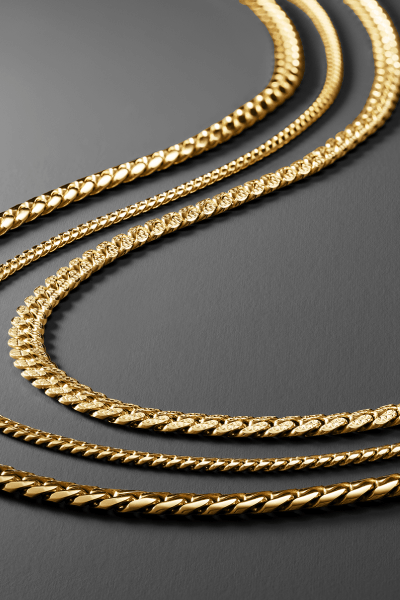 Collection of yellow gold chain necklaces in curb, rope, Figaro and textured link styles.