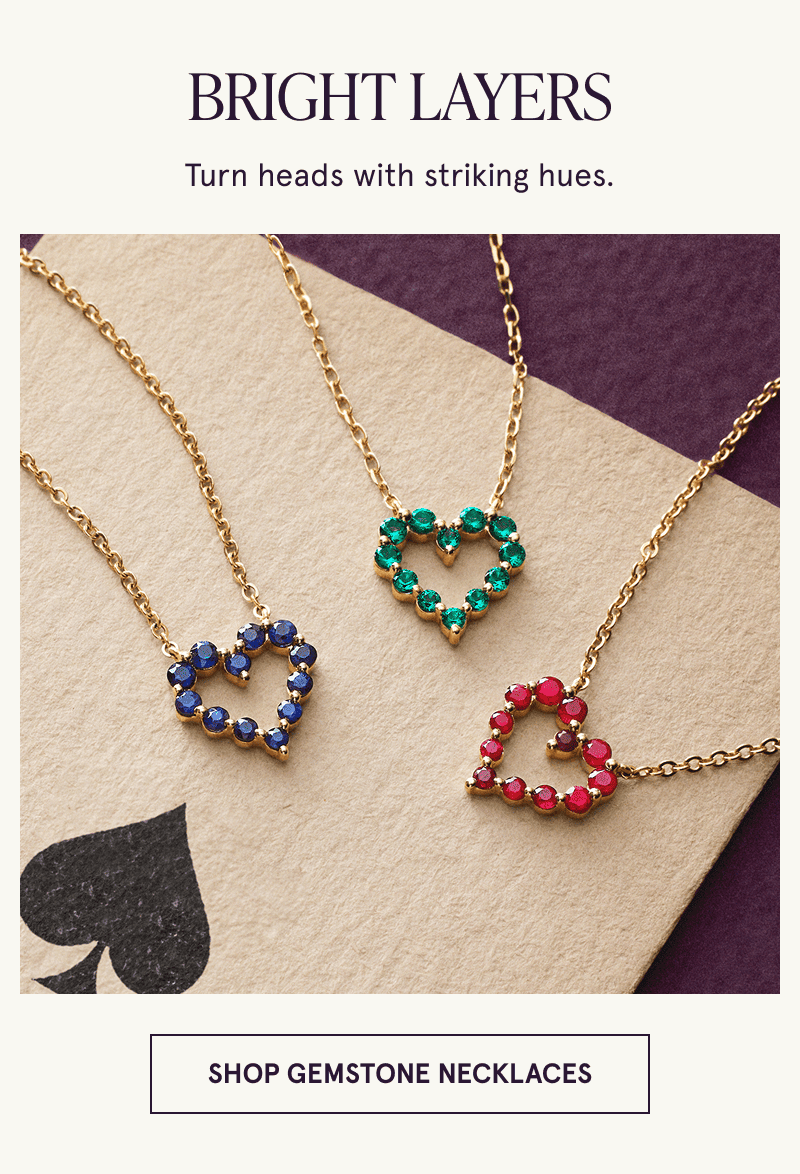 Three necklaces with heart shaped gemstone pendants rest on a playing card. Bright looks. Click to shop gemstone necklaces