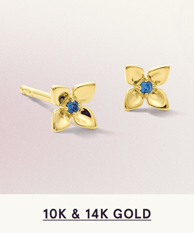 A pair of gold flower shaped studs with blue gemstone accents. Click here to shop 10K and 14K gold 