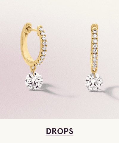 A pair of gold diamond hoop drop earrings. Click here to shop drops