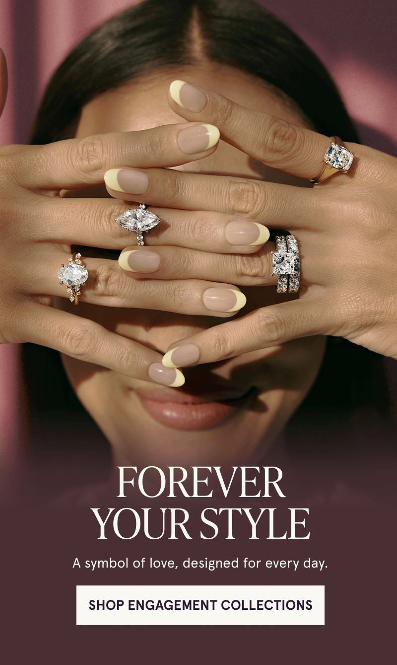 Model with hands over face displaying multiple diamond engagement rings. Click here to shop engagement collections