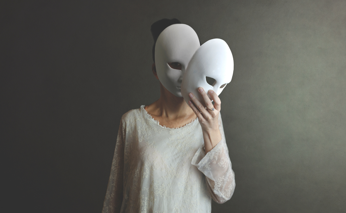 Woman taking off a mask to reveal another mask underneath