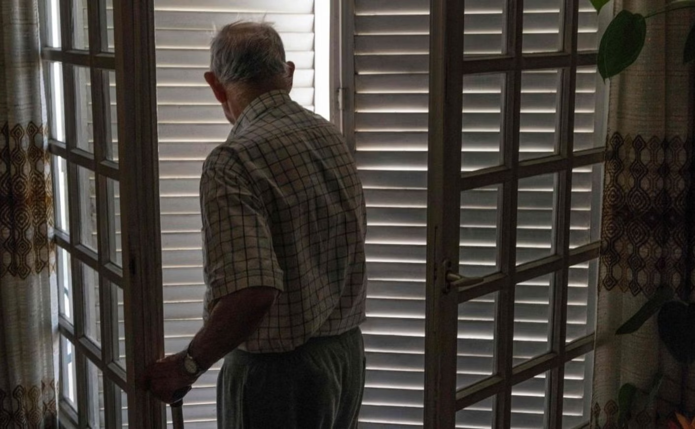 An elderly man leaving the house