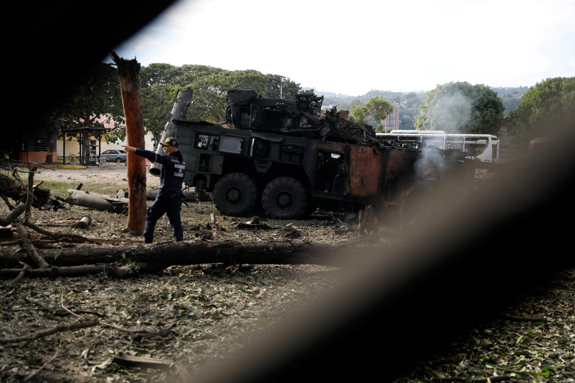 A firefighter gestures near a destroyed antiaircraft unit at La Carlota military air base after U.S. strikes in Caracas, Venezuela, on January 3, 2026.