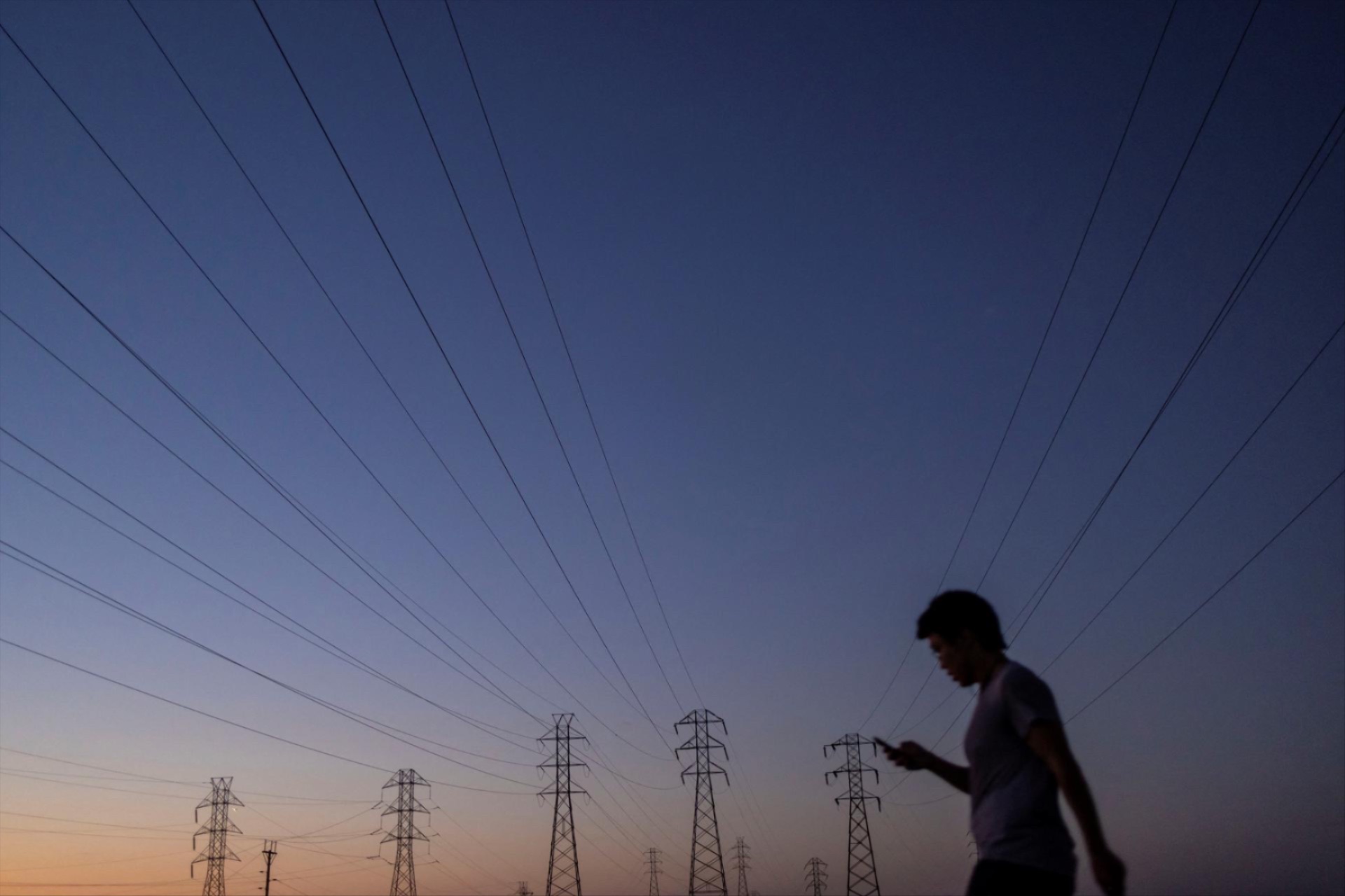 A man walks by power lines in Mountain View, California, August 17, 2022. 