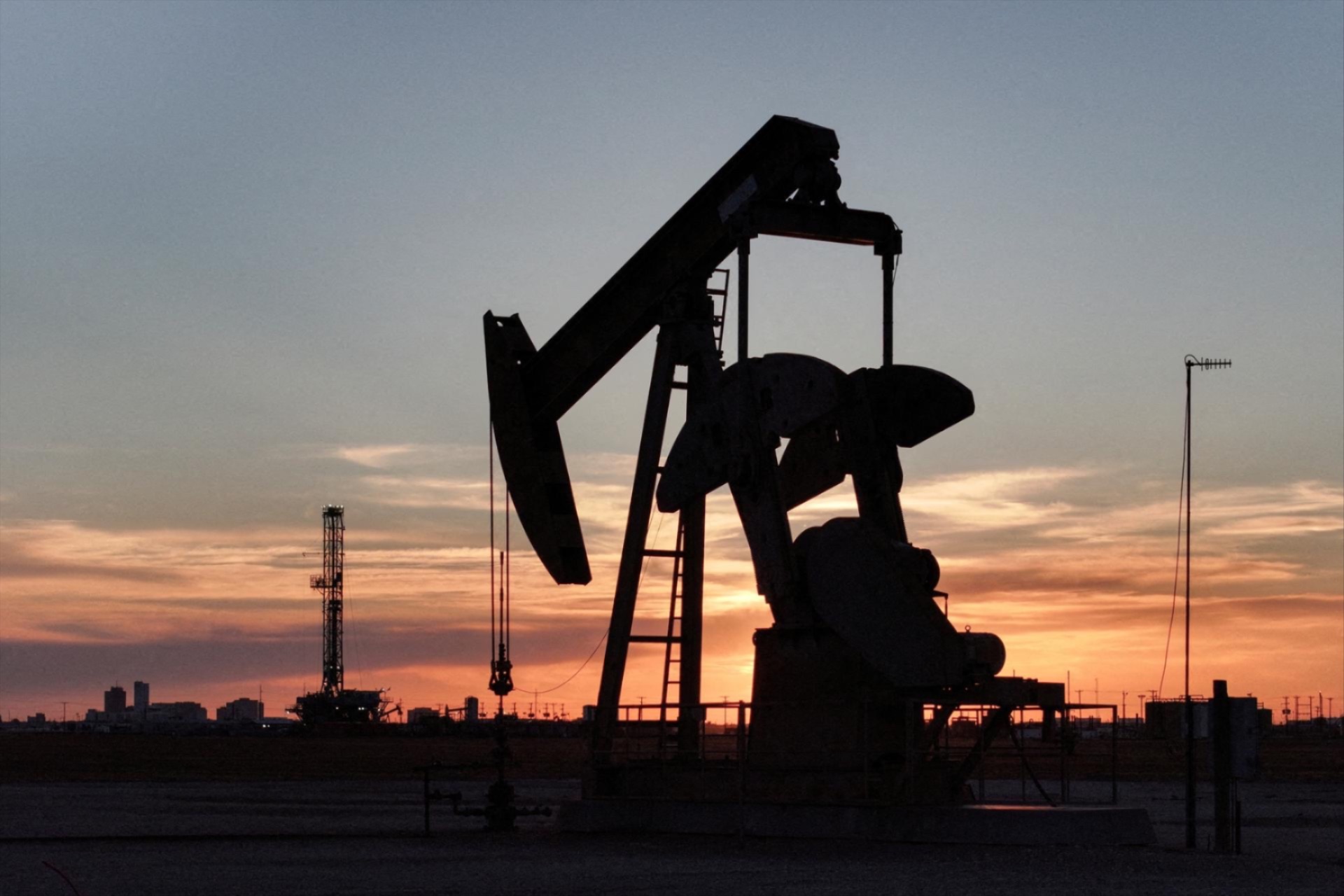 a pump jack and drilling rig south of Midland, Texas, U.S. June 11, 2025. 