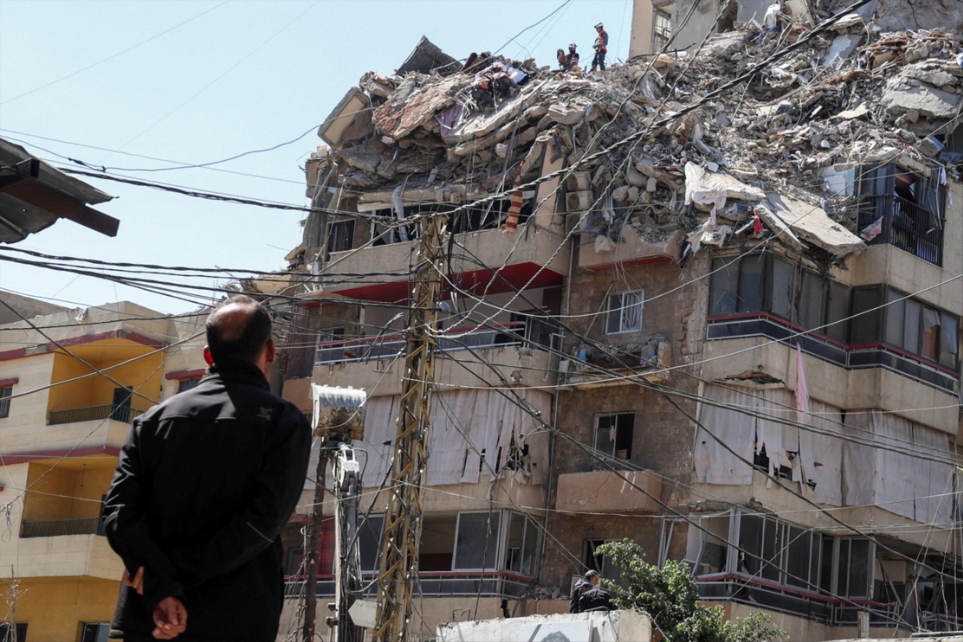 A man watches as rescuers work at the site of an Israeli strike that took place yesterday, in the southern suburbs of Beirut, Lebanon, May 7, 2026.