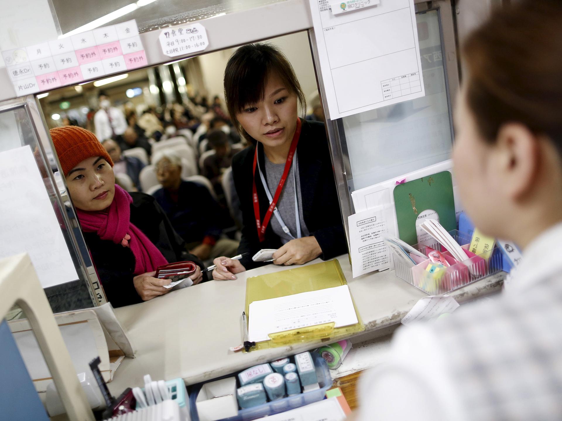 Dang Nguyen Thuc Vien, a 32-year-old daughter of refugees from south Vietnam, assists a Vietnamese resident as an interpreter, at a hospital, in Kanagawa prefecture, Japan, on November 25, 2015.