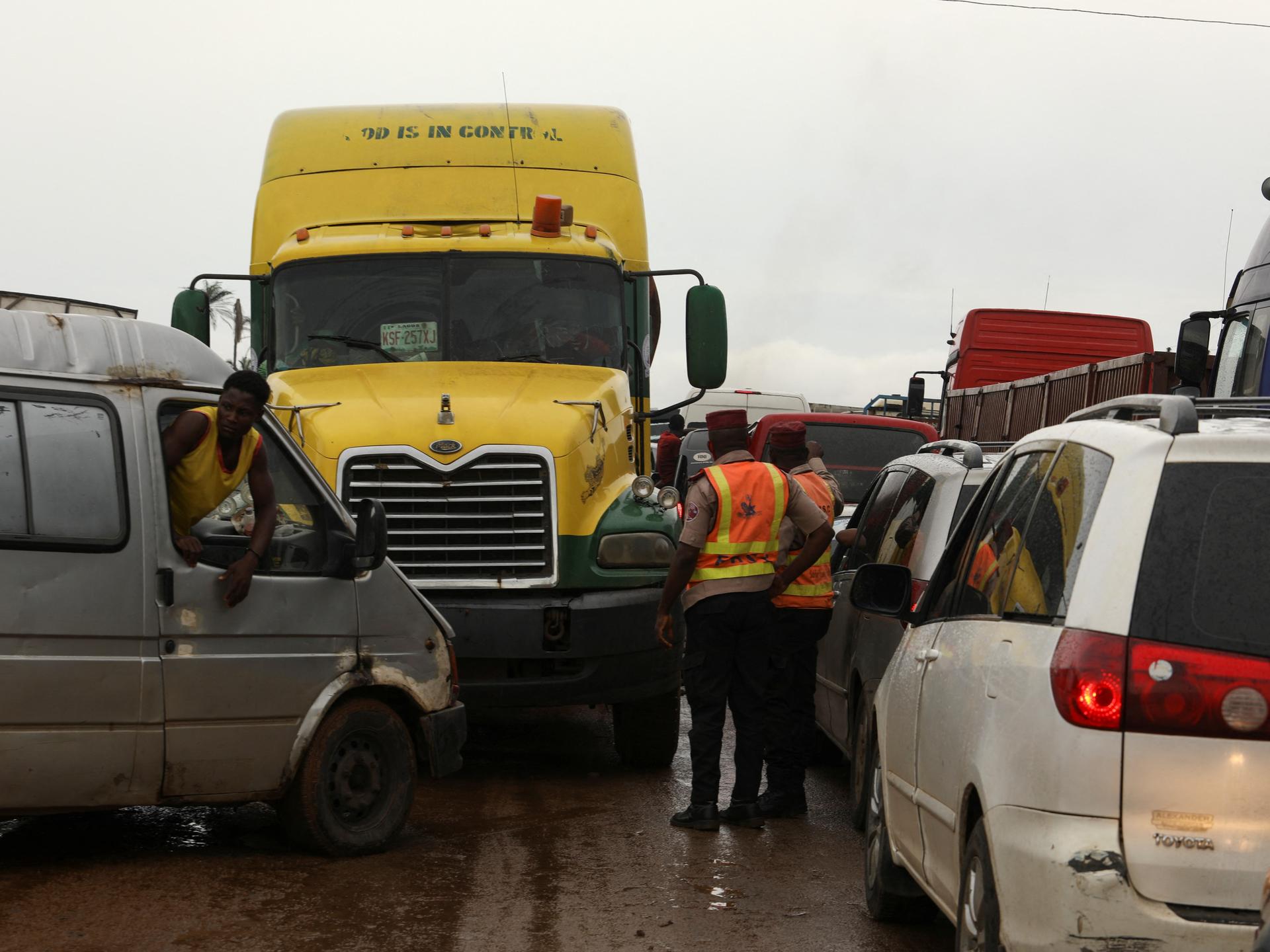 Road safety officers stand, as traffic is blocks a road, in Lokoja, Nigeria, on October 13, 2022. 