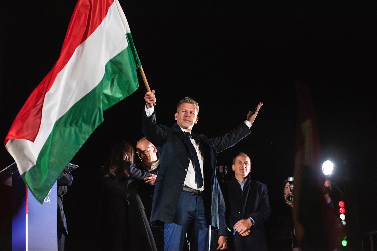 Peter Magyar waves the Hungarian flag after his speech during his party’s election night event in Budapest on Sunday, April 12, 2026. 