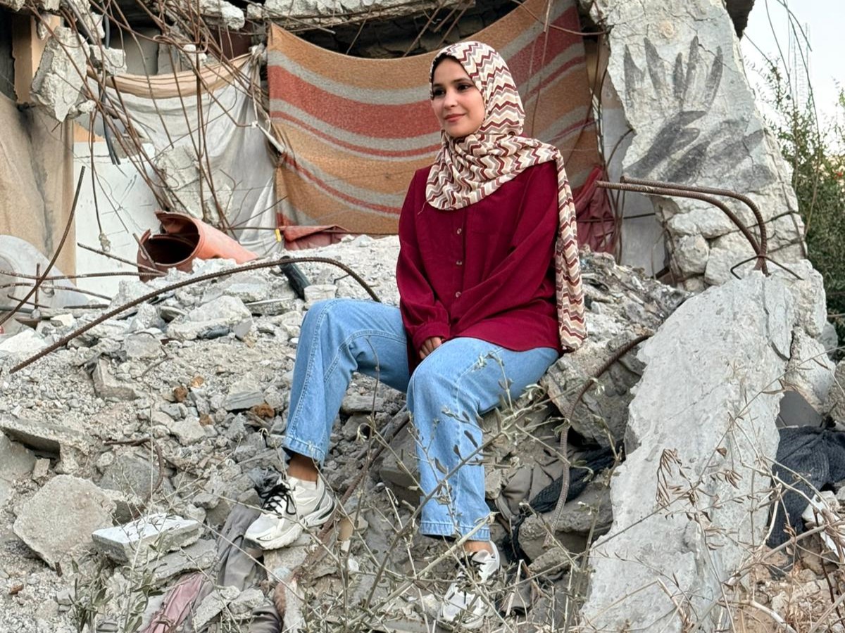 Project HOPE Gaza Human Resources Coordinator Nouralhuda Abu Gefra sits in the rubble of her partially damaged house in Gaza, on October 14, 2025.